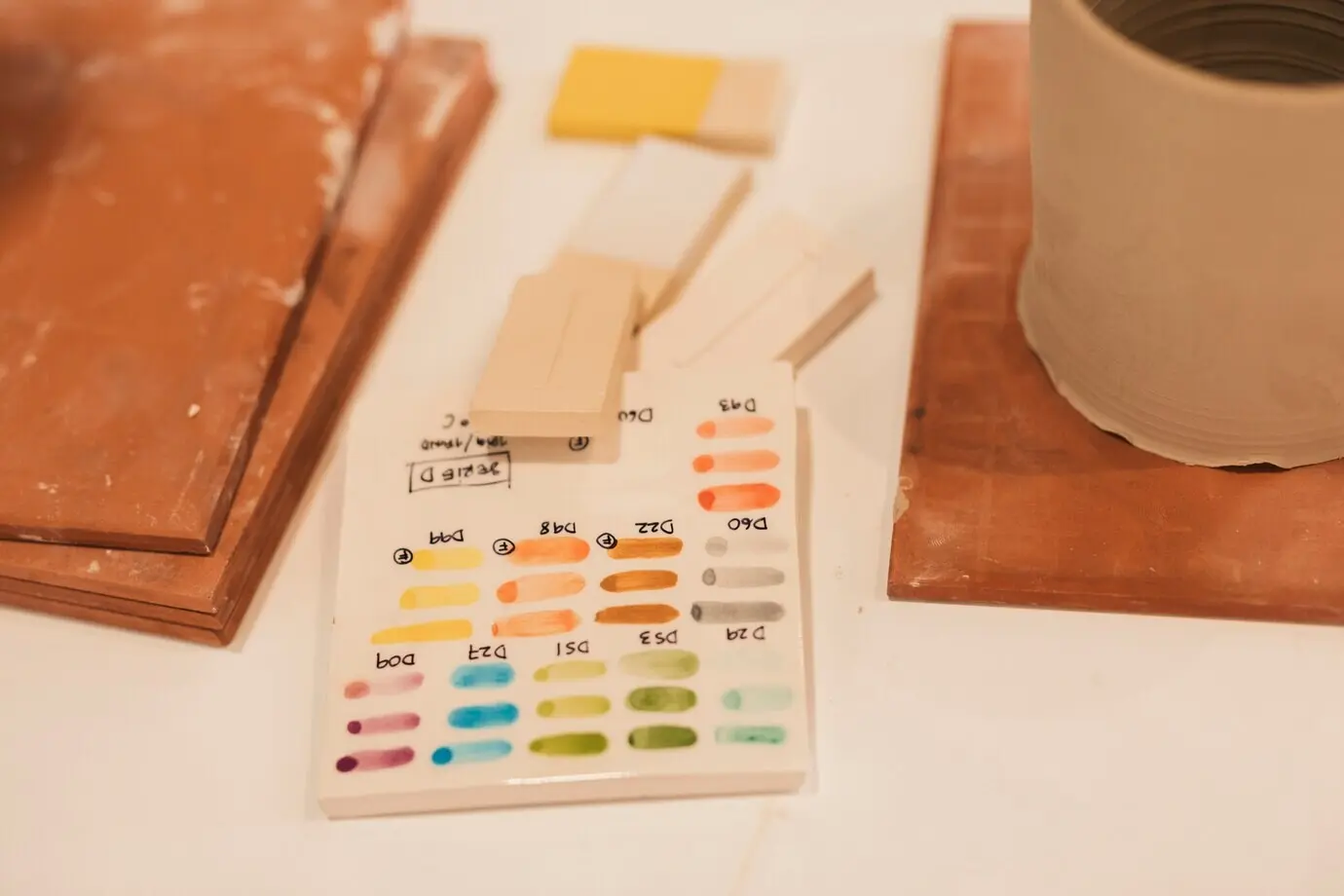 An overhead view of colored glazed ceramic tile samples on a table